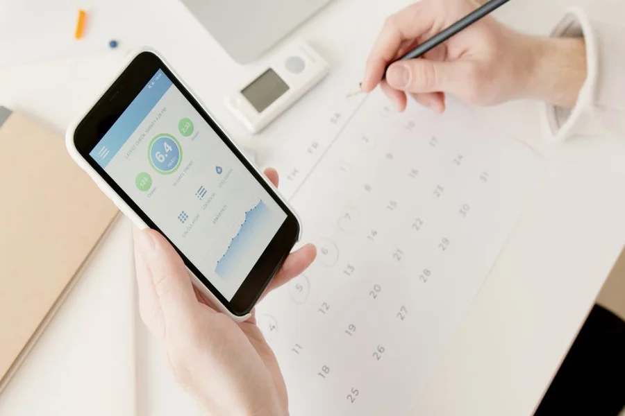 A person reviewing their fitness progress on a smartphone app, showing graphs of weight lifted over time.
