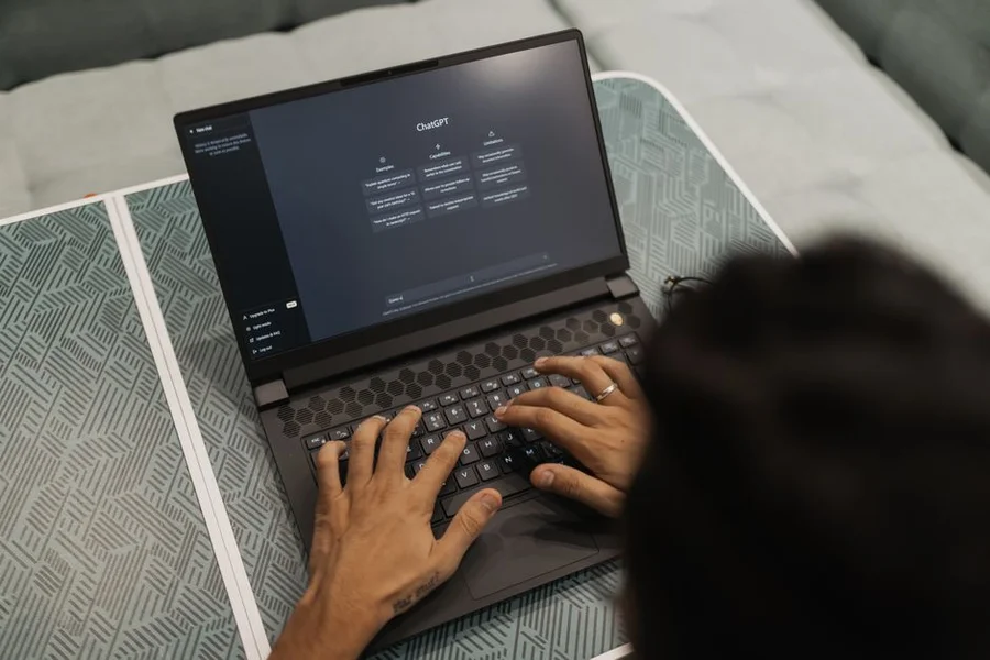 A professional remote worker using AI tools on dual monitors in a bright home office