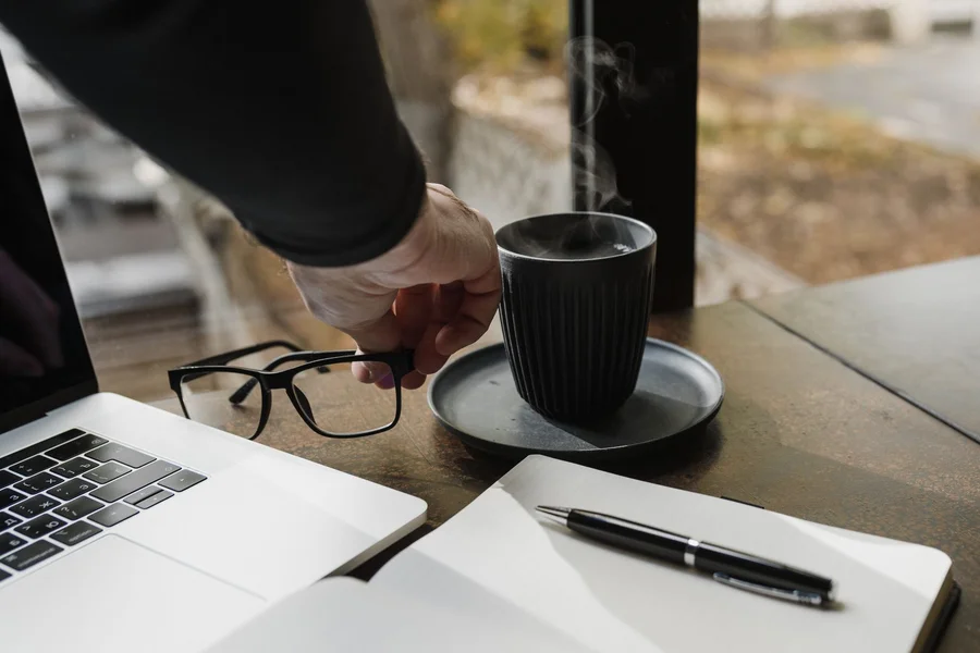 A professional taking a relaxing break at a clean desk while computer software processes tasks