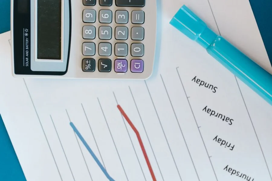 Automation ROI Analysis A desk setup with a financial calculator and growth charts showing positive ROI