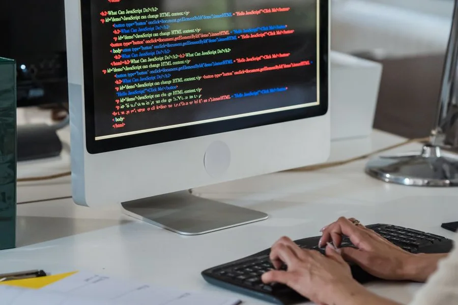 AI Code Editor Workspace A software developer desk showing lines of code displayed on a computer monitor