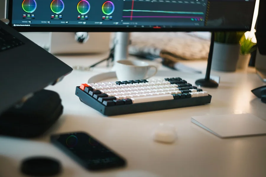 Video Music Editing Workspace A content creator editing video background music at a desk with a laptop and coffee