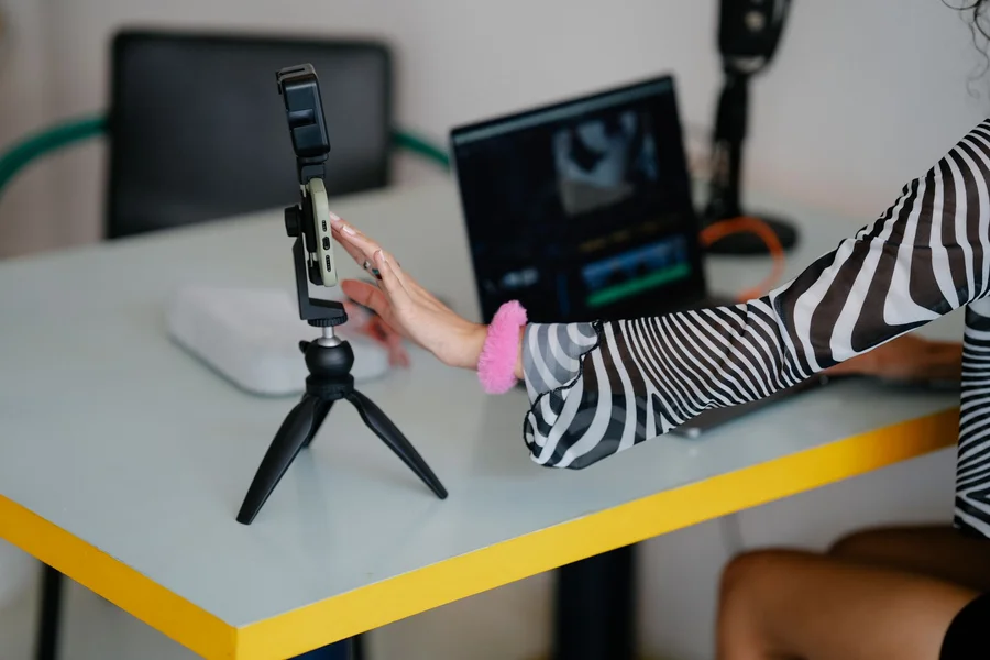 A content creator editing short social media clips on a smartphone and laptop
