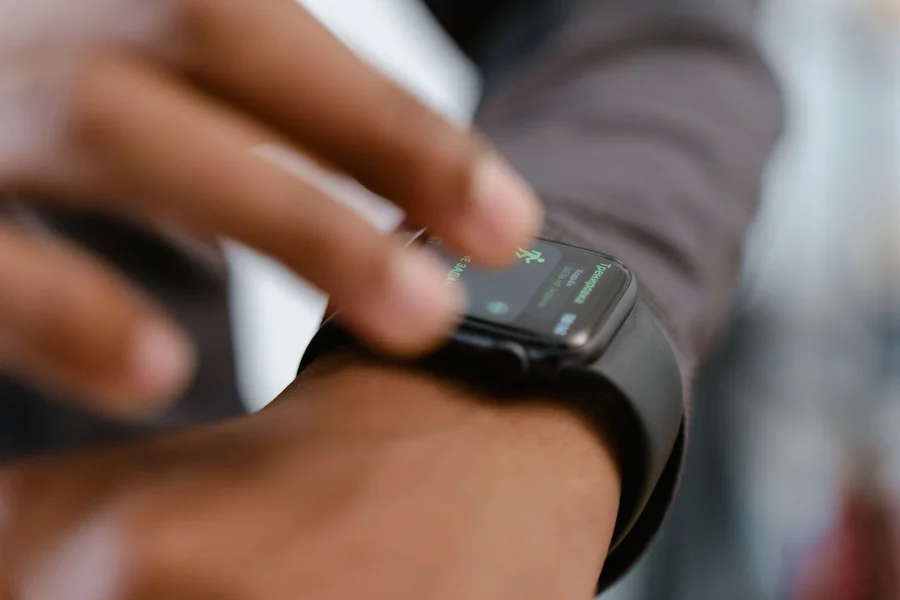 A person wearing a fitness tracker smartwatch while working at a desk