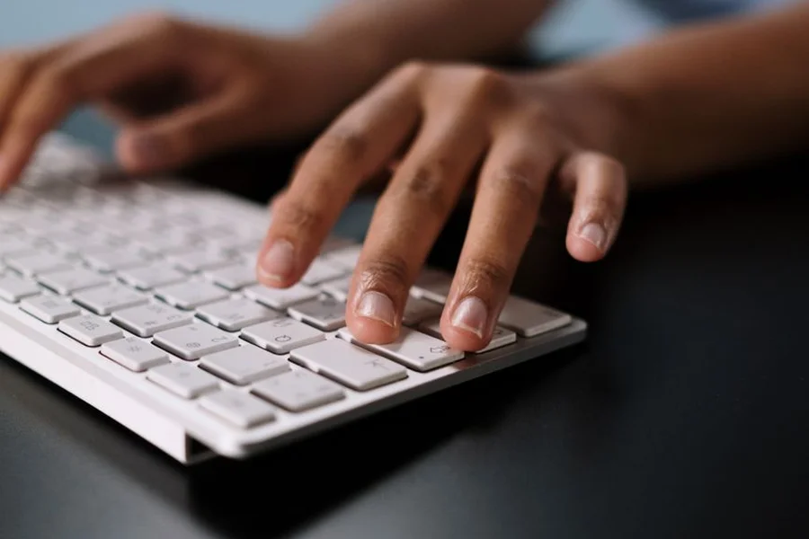 AI Digital Workflow Hands typing on a laptop keyboard with digital background visual elements