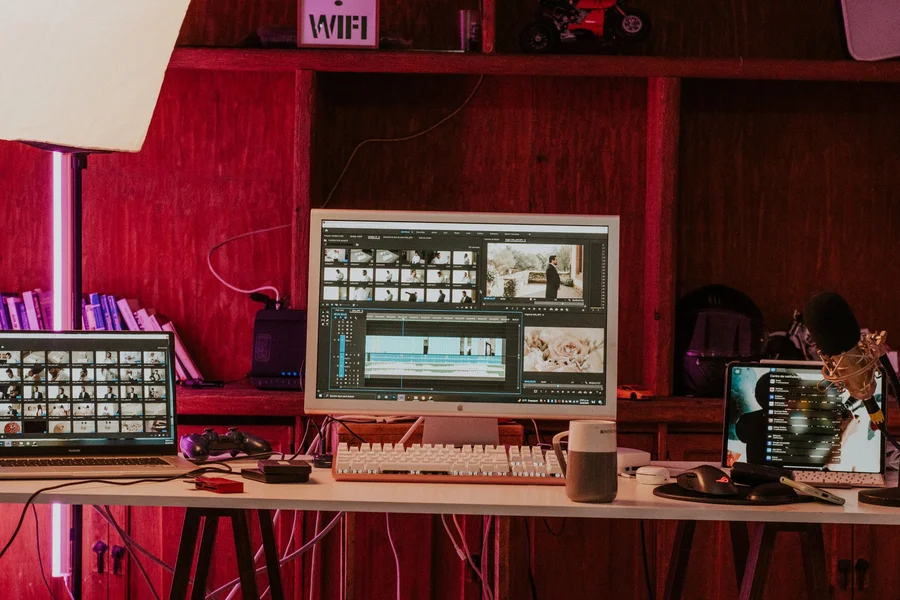 A content creator editing voiceover audio tracks at a modern desktop workstation
