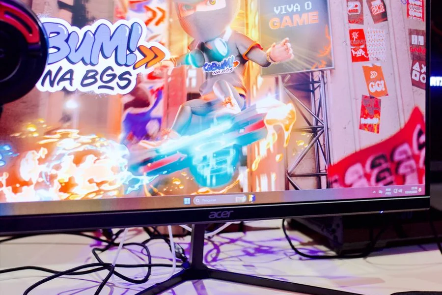 A gaming monitor showing colorful indie chameleon character camouflage mechanics on screen