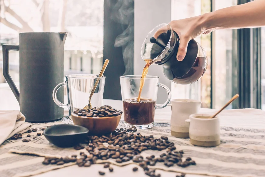 Pouring hot coffee from glass carafe of Premium Levella 4-cup coffee maker PCM5422B