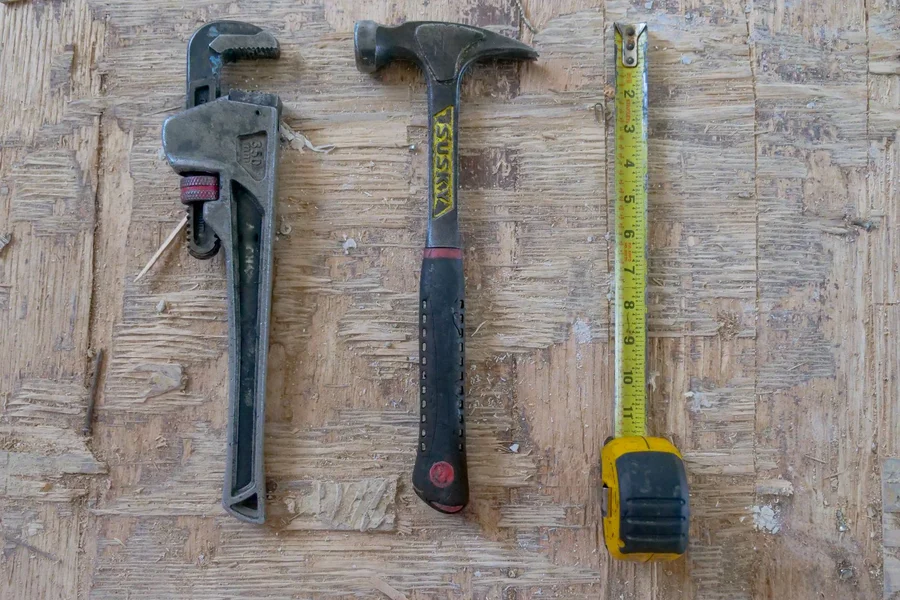 Stanley Hammer in Workshop Toolbox A collection of hand tools including a yellow fiberglass hammer, tape measure, and toolbox